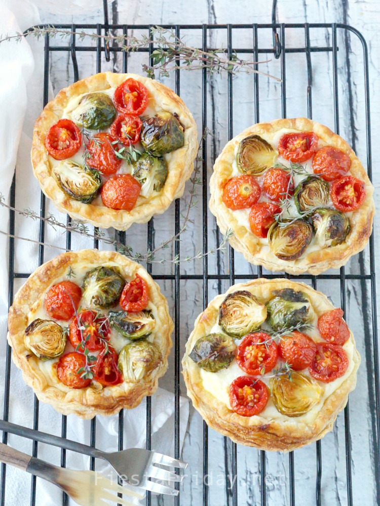 This Brussels Sprouts Cherry Tomato Tart is the perfect Christmas appetizer. The round red and green-colored vegetables are like Christmas ornaments nestled on a creamy and cheesy bed with a crispy puff pastry shell! - FiestaFriday.net
#appetizer #christmas #tart #cheese #fontina #ricotta #brusselssprouts #cherrytomato