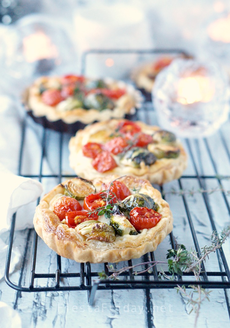 This Brussels Sprouts Cherry Tomato Tart is the perfect Christmas appetizer. The round red and green-colored vegetables are like Christmas ornaments nestled on a creamy and cheesy bed with a crispy puff pastry shell! - FiestaFriday.net #appetizer #christmas #tart #cheese #fontina #ricotta #brusselssprouts #cherrytomato
